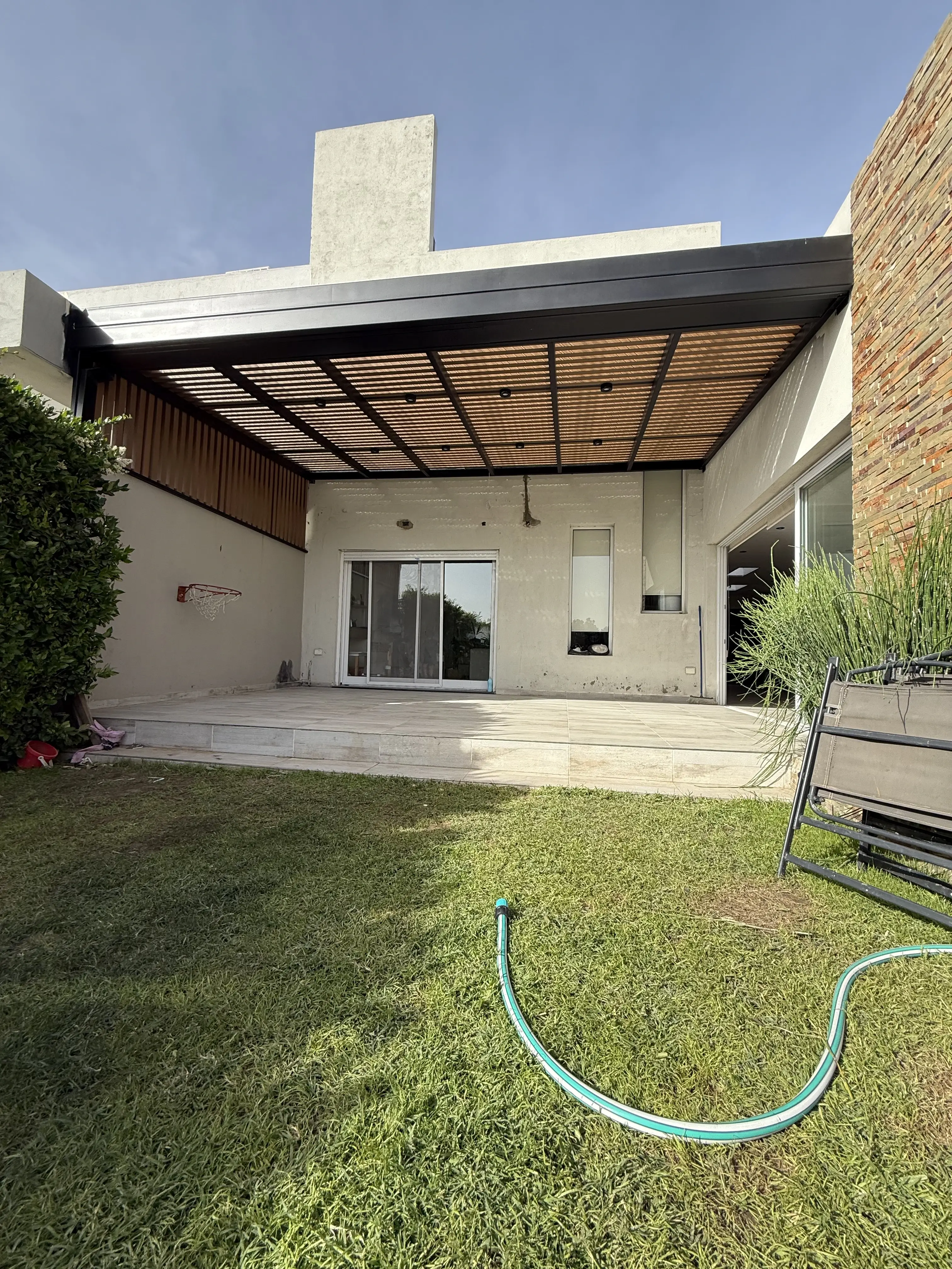 Pérgola de hierro integrada al jardín de vivienda en Buenos Aires